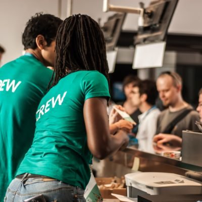 Grupo de trabajadores detrás de la barra con camiseta verde personalizada